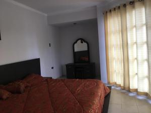 a bedroom with a bed with a red comforter and a mirror at Como en tu casa in Tarija