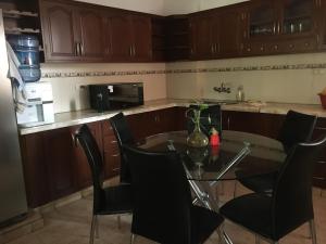 a kitchen with a table and chairs in a kitchen at Como en tu casa in Tarija