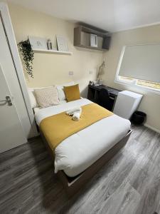 a bedroom with a large bed with a yellow blanket at west walk house in Nottingham