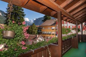 a balcony with a view of flowers and buildings at Alpenblick Hotel & Restaurant Wilderswil by Interlaken in Wilderswil