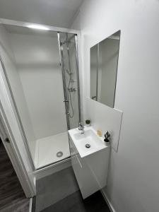 a white bathroom with a sink and a mirror at west walk house in Nottingham