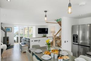 una cucina e un soggiorno con tavolo e sedie di Harbour Master's House a Portreath