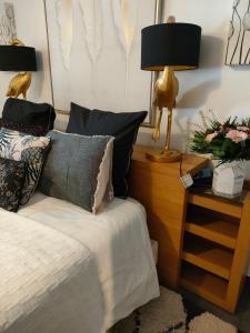 - une chambre avec un lit et une table de chevet avec une lampe dans l'établissement La suite 27, chambre d'hôtes de charme, à Guingamp