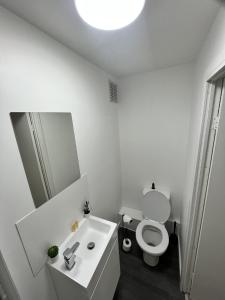 a white bathroom with a toilet and a sink at west walk house in Nottingham