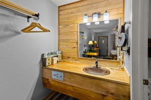 uma casa de banho com um toucador de madeira e um espelho. em The Lookout Lodge em Eureka Springs