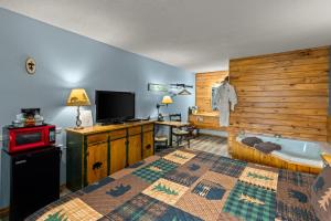 um quarto com uma cama, uma televisão e uma banheira em The Lookout Lodge em Eureka Springs