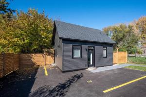 ein kleines schwarzes Haus auf einem Parkplatz in der Unterkunft Stylish and Cozy Tiny House with King bed in Kitchener