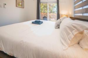 a large white bed in a bedroom with a window at Stylish and Cozy Tiny House with King bed in Kitchener