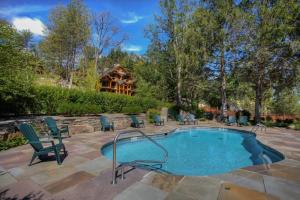 a swimming pool with chairs and a house in the background at Oneida Lodge North in Cooperstown