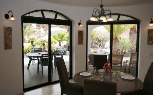 a dining room with a table and chairs and a patio at Casa Ronda in Charco del Palo