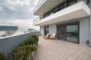 een balkon van een huis met 2 stoelen en een patio bij Spacious Modern Apartments With Great Rooftop View in Athene