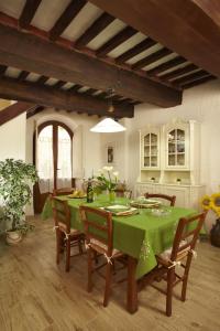 ein Esszimmer mit einem grünen Tisch und Stühlen in der Unterkunft Appartamento San Simone in Castiglione della Pescaia