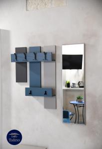 un espejo colgado en una pared con un estante azul en B&B Talino, en Trani
