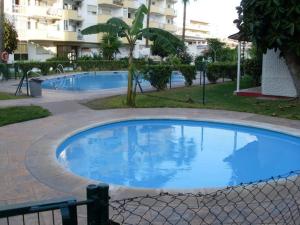 a large blue swimming pool in front of a building at Bungalow Aloha Torres in Torremolinos