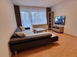sala de estar con sofá y TV de pantalla plana en Viktoria's Wohnung in Kaarst, en Kaarst
