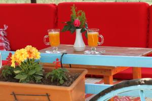 dos vasos de zumo de naranja en una mesa con flores en Mila Pansiyon, en Cıralı