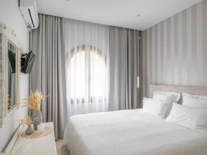 バリにあるBali Bay Villaのベッドルーム(白いベッド1台、窓付)