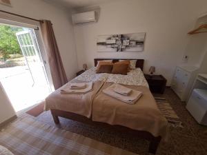 1 dormitorio con 1 cama con 2 toallas en B&B Quinta da Romãzeira, en São Bartolomeu de Messines