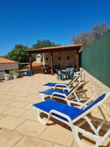 a row of lounge chairs sitting on a patio at B&B Quinta da Romãzeira in São Bartolomeu de Messines