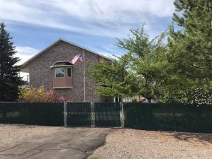 ein Haus mit einem Zaun und einer amerikanischen Flagge in der Unterkunft Enjoy The Outback+ Indoor Hot tub+Games+Puzzles+Tennis Court in Mount Pleasant