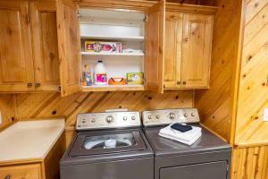 eine Küche mit einem Herd und Holzschränken in der Unterkunft Enjoy The Outback+ Indoor Hot tub+Games+Puzzles+Tennis Court in Mount Pleasant + 21 Fotos