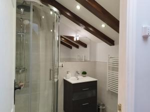 W łazience znajduje się szklana kabina prysznicowa i umywalka. w obiekcie Casa Rural Madera y Sal w mieście Salinas de Añana