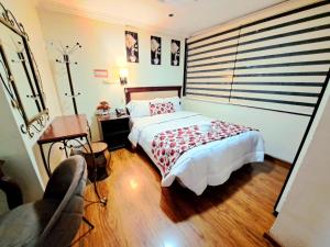 a bedroom with a bed and a table and a chair at Hotel Virgen del Cisne in Loja