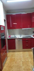 uma cozinha com armários vermelhos e um lavatório em Bungalow Gran Alacant em Gran Alacant