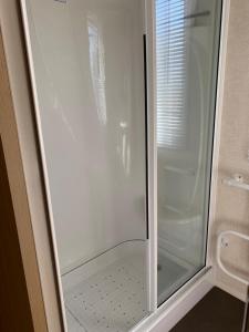 a shower with a glass door in a bathroom at Tyn llan in Llanddeusant