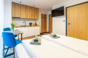 2 łóżka w pokoju ze stołem i kuchnią w obiekcie Apartamenty Pod Wyciągiem w Wiśle