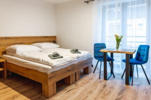 1 dormitorio con 1 cama, mesa y sillas en Apartamenty Pod Wyciągiem, en Wisła
