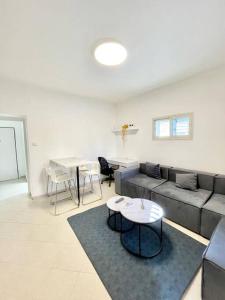 Rambam BEACH apartment في حيفا: غرفة معيشة مع أريكة وطاولة