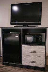 a microwave and a tv on a entertainment center with a microwave and a microwave at Salt Creek Lodge in Graham