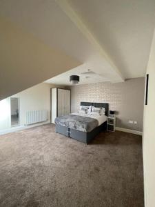 a bedroom with a large bed in an attic at Swindon City Center 2bed apartment with Parking and WiFi in Swindon