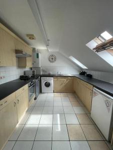a large kitchen with a white tiled floor at Swindon City Center 2bed apartment with Parking and WiFi in Swindon