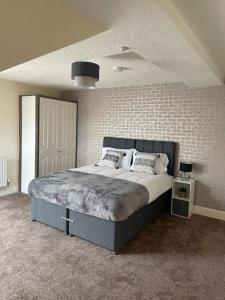 a bedroom with a bed and a brick wall at Swindon City Center 2bed apartment with Parking and WiFi in Swindon