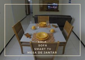 een witte tafel met twee stoelen en een gele plaat bij TH 3406 - Flat de Três Quartos in Governador Valadares