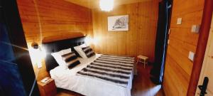ein Schlafzimmer mit einem Bett in einem Holzzimmer in der Unterkunft Chalet l'Appel de la Forêt in Gérardmer