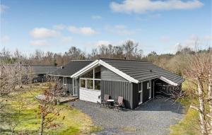 une maison avec un hangar noir et blanc dans l'établissement Nice Home In lbk With Wifi, à Ålbæk