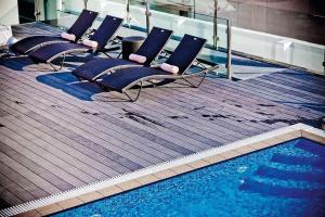 a row of chairs sitting next to a swimming pool at Sliema Tigne Suites in Sliema