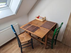 un tavolo in legno e 2 sedie in una stanza di Großes Zimmer mit eigenem Bad/Flur a Emsbüren