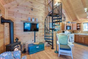 a living room with a spiral staircase in a log cabin at Maine Lodging Near Acadia National Park! in Bernard