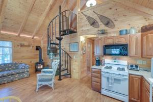 a kitchen with a spiral staircase in a log cabin at Maine Lodging Near Acadia National Park! in Bernard