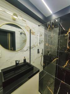 a bathroom with a black sink and a mirror at M&K Apartament Ramirasz Wyspa Sobieszewska in Gdańsk