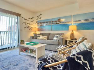 a living room with a couch and a table at Pier Pressure Beachfront Wpool in Cocoa Beach