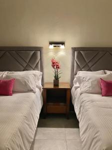 a bedroom with two beds and a table with flowers on it at HOTEL CASABLANCA in Xilitla