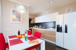 eine Küche mit einem weißen Tisch und roten Stühlen in der Unterkunft Polina's Sunset Apartment in Dubrovnik