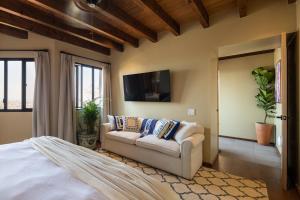 una camera da letto con un divano e una TV a schermo piatto di Panorama de la Parroquia a San Miguel de Allende