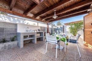 un patio al aire libre con mesa y sillas en BUNGALOWS LOS ARCOS 77 en San Bartolomé