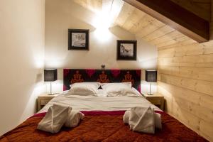 a bedroom with a large bed with two lamps at CGH Résidence Boutique Le Napoléon in Montgenèvre